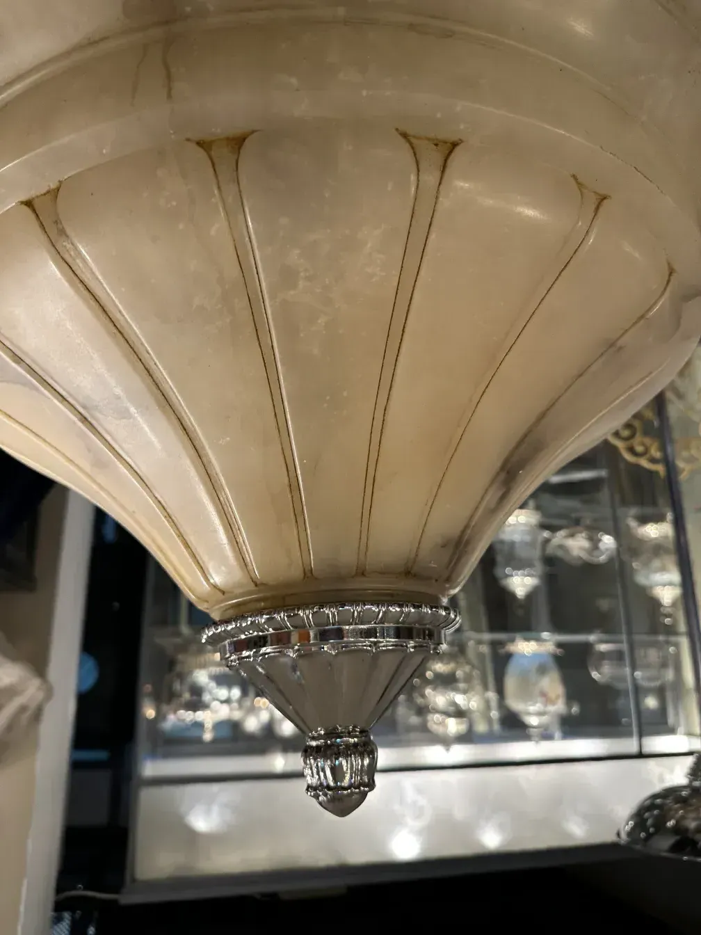 Antique hanging lamp with elegant design, shiny details in a decorative setting.