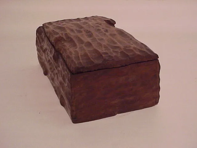 Antique wooden box with rough texture and rectangular shape.