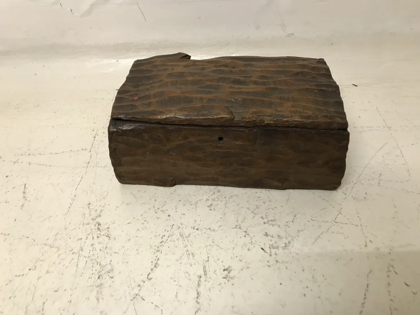 Antique wooden box with unique texture, neutral background.