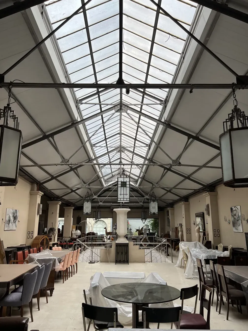 दो प्राचीन लालटेन फर्नीचर वाले देहाती परिवेश में लटके हुए हैं।