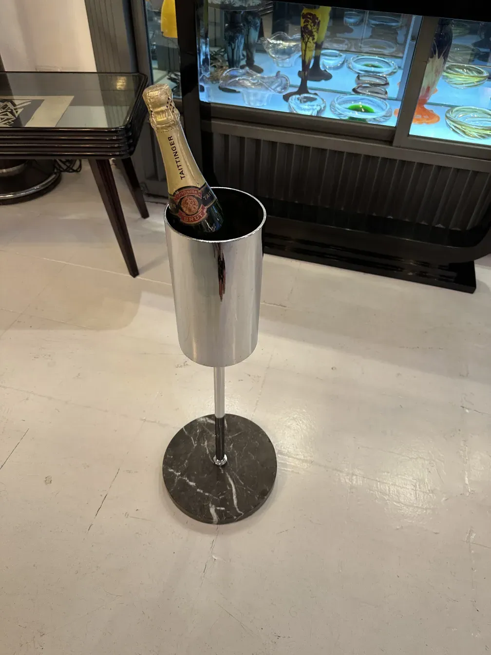 Antique champagne cooler with marble stand on light background