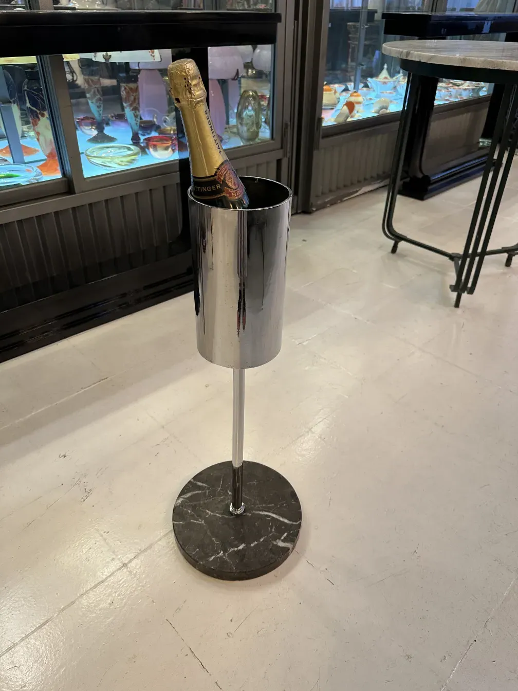 Shiny antique champagne cooler with a marble base, elegant in a cozy setting