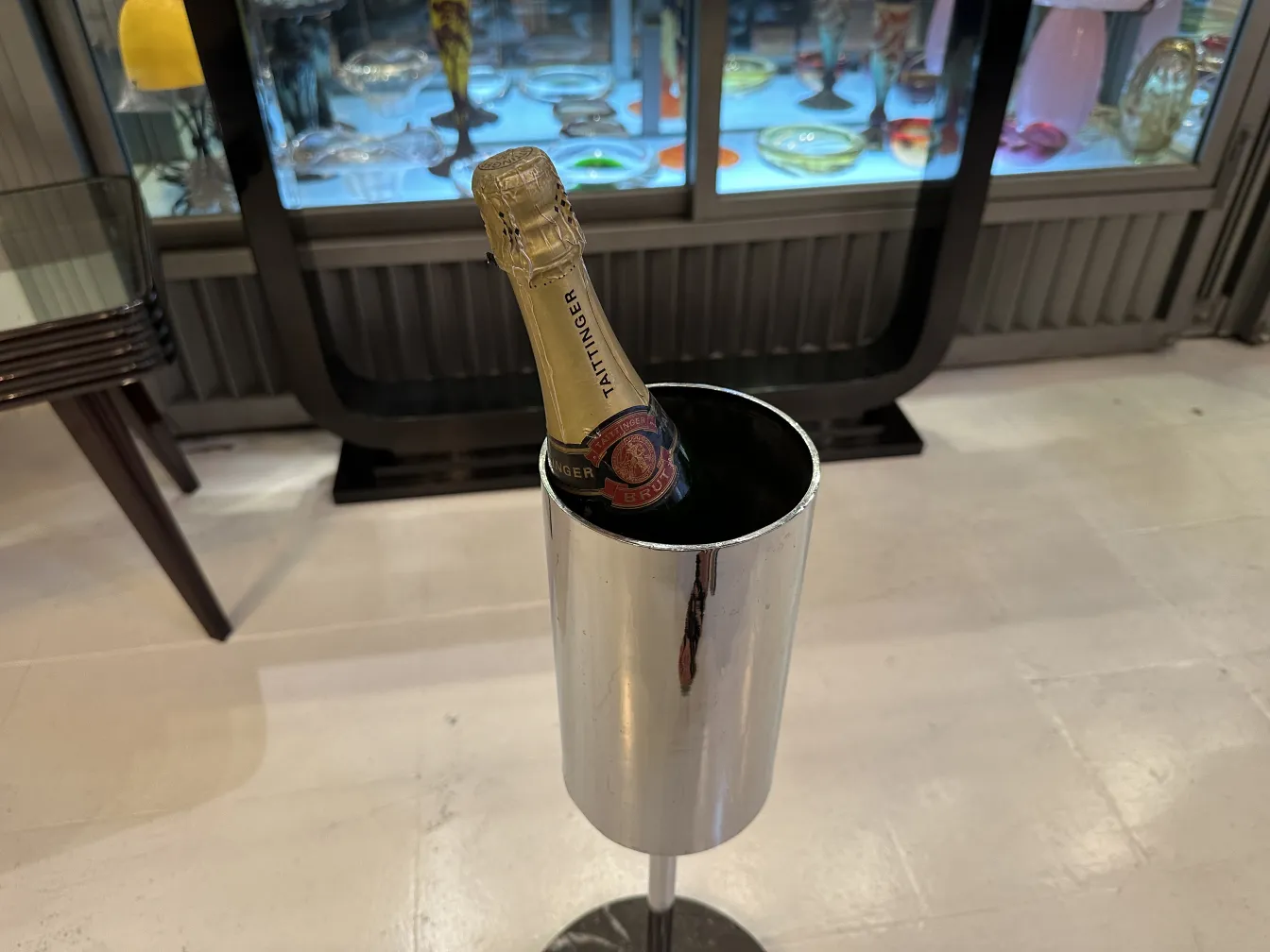 Antique champagne cooler with a champagne bottle in an elegant setting.