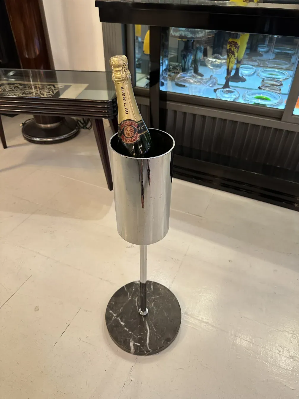 Antique metallic champagne cooler with a marble base, suitable for serving champagne.