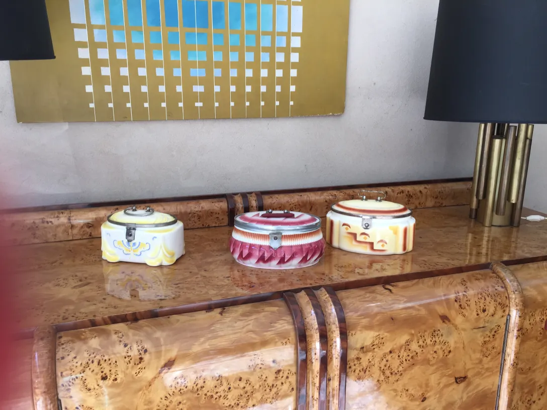 Antique sideboard with colorful ceramic accessories on top.