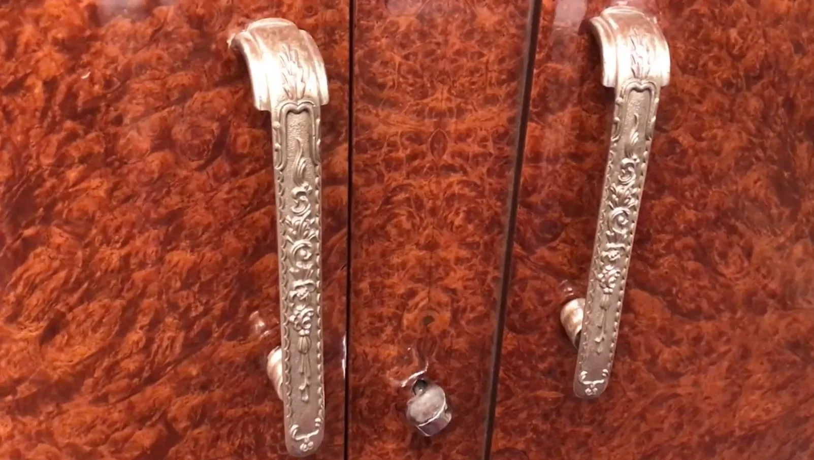 Antique sideboard with ornate handles and a glossy finish