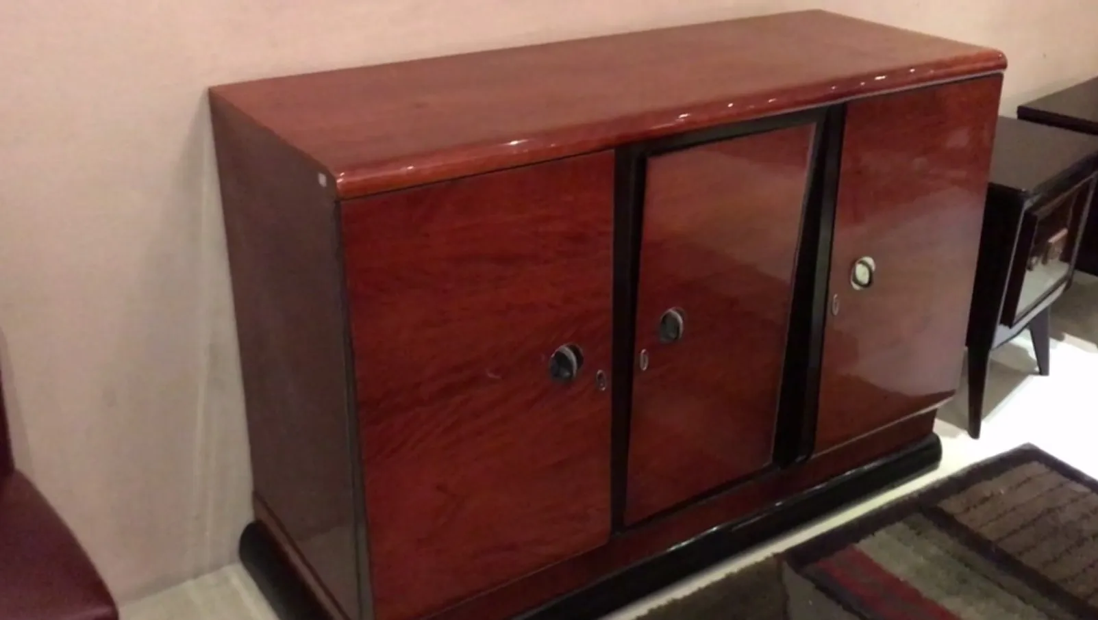 Antique sideboard with glass doors and shiny finish, in a cozy setting.