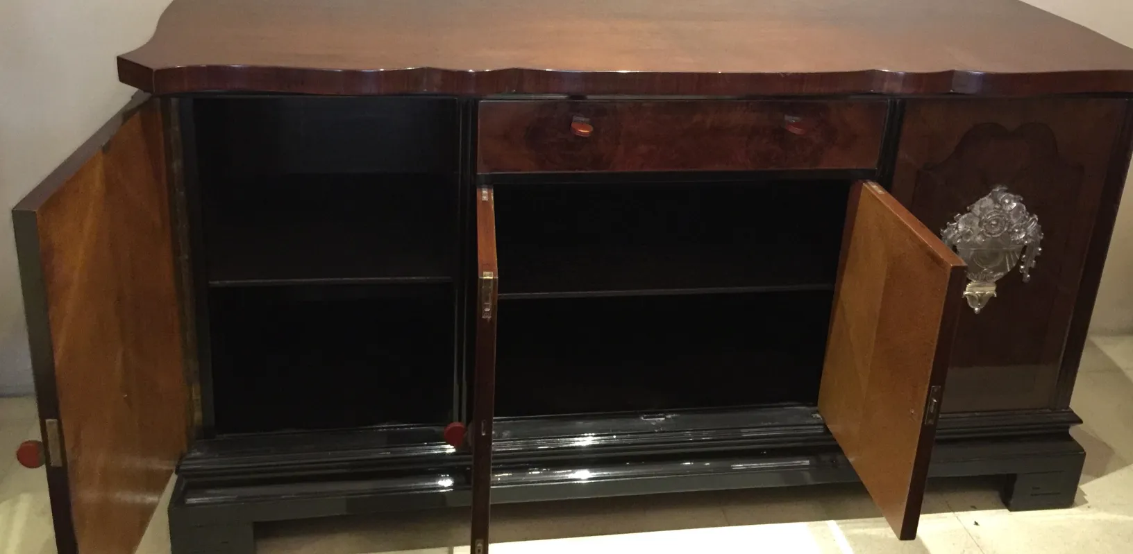 Antique sideboard with open doors and decorative details.