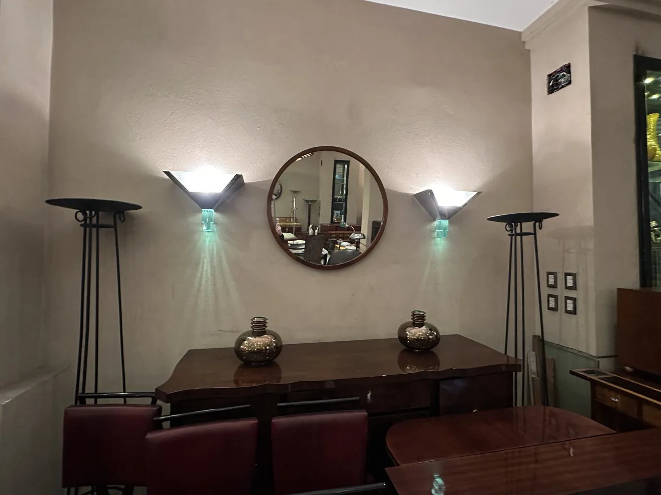 Antique sideboard with decorative mirror and modern lamps, warm ambiance.