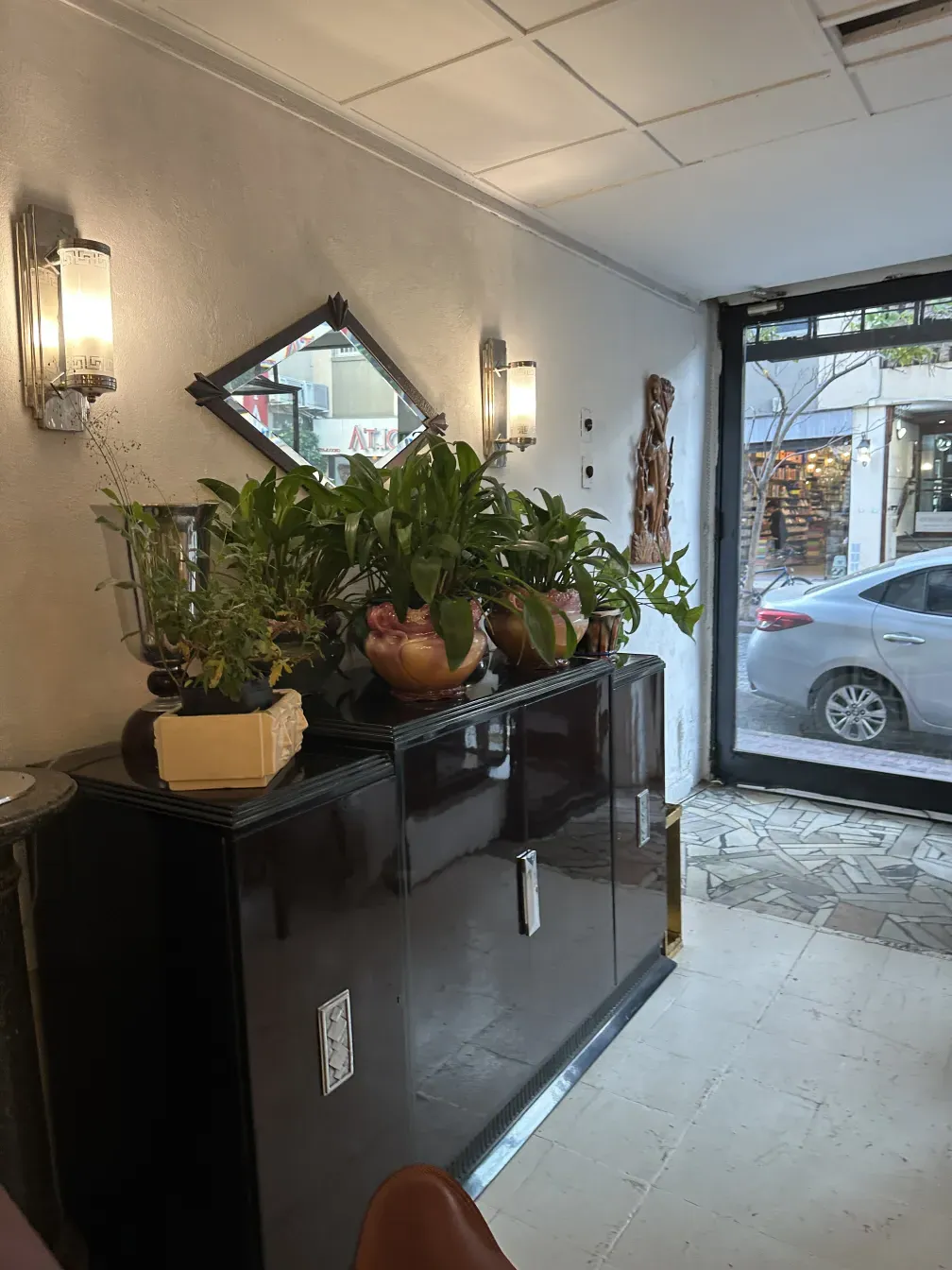 antique sideboard in dark color decorated with plants and mirror