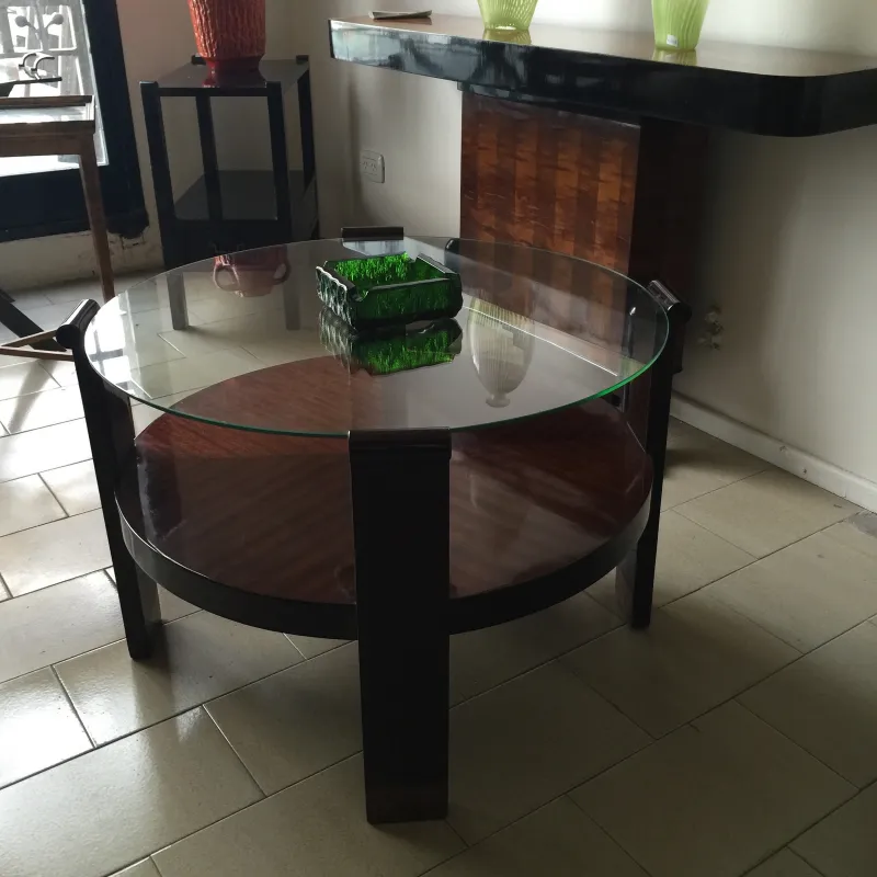Antique standing ashtray in a modern living room, with glass table and decorative items.