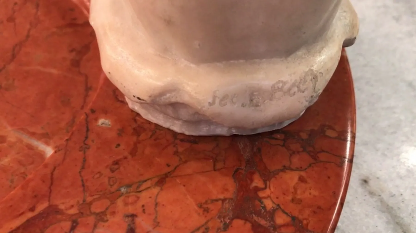 Antique standing ashtray on red marble background