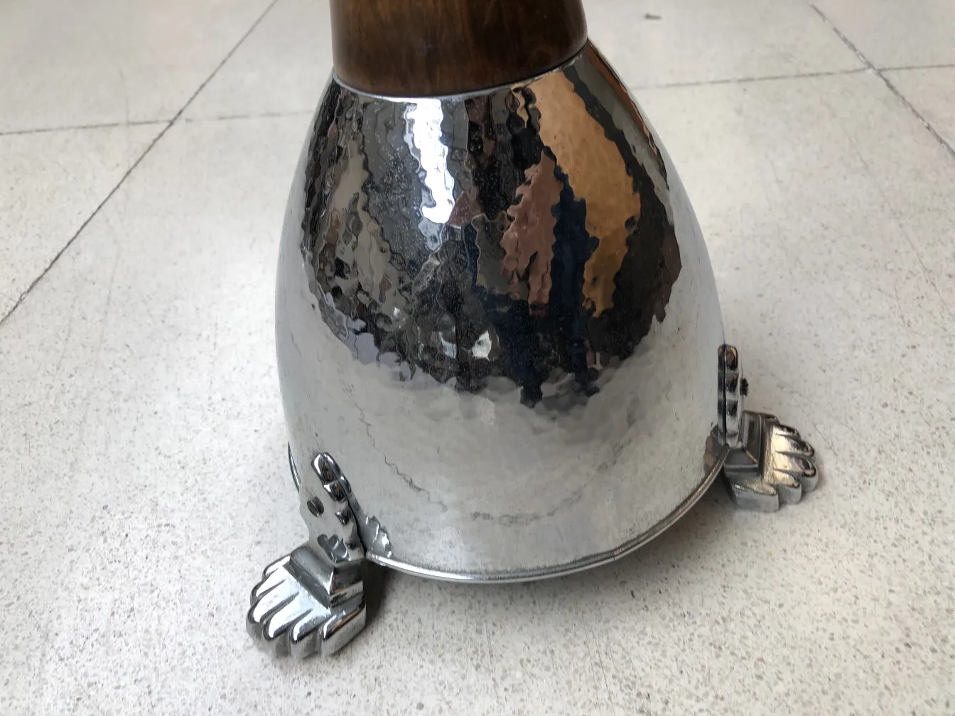 Standing ashtray with elegant base and decorative feet, neutral setting.