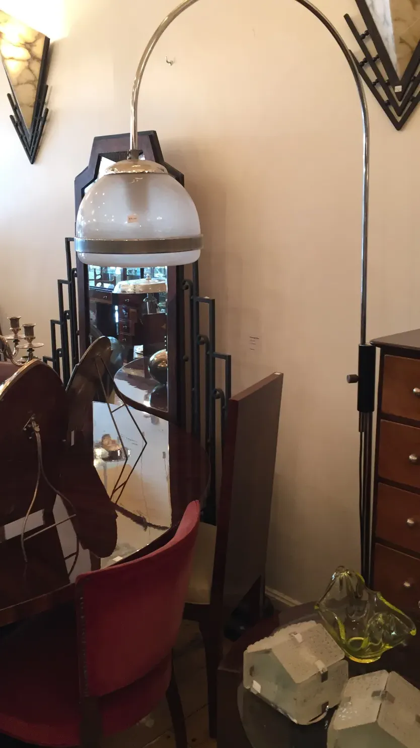 Антикоренный торшер с изогнутым и элегантным дизайном, уютная атмосфера, декоративные элементы на заднем плане.