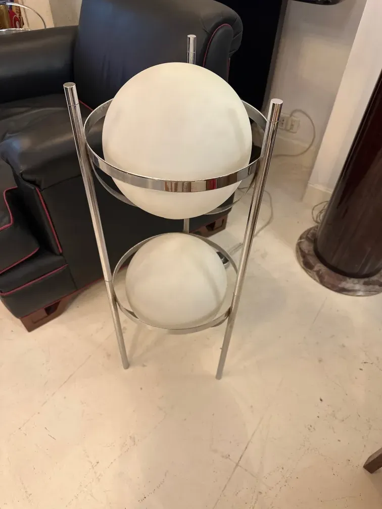 Антикварный торшер с металлической основой и двумя белыми шарами, в современном окружении.