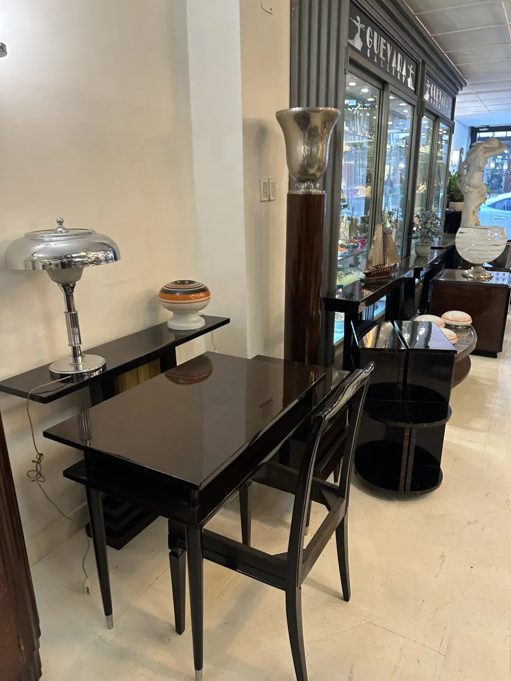 Античный торшер в элегантной обстановке, рядом с другими декоративными предметами.