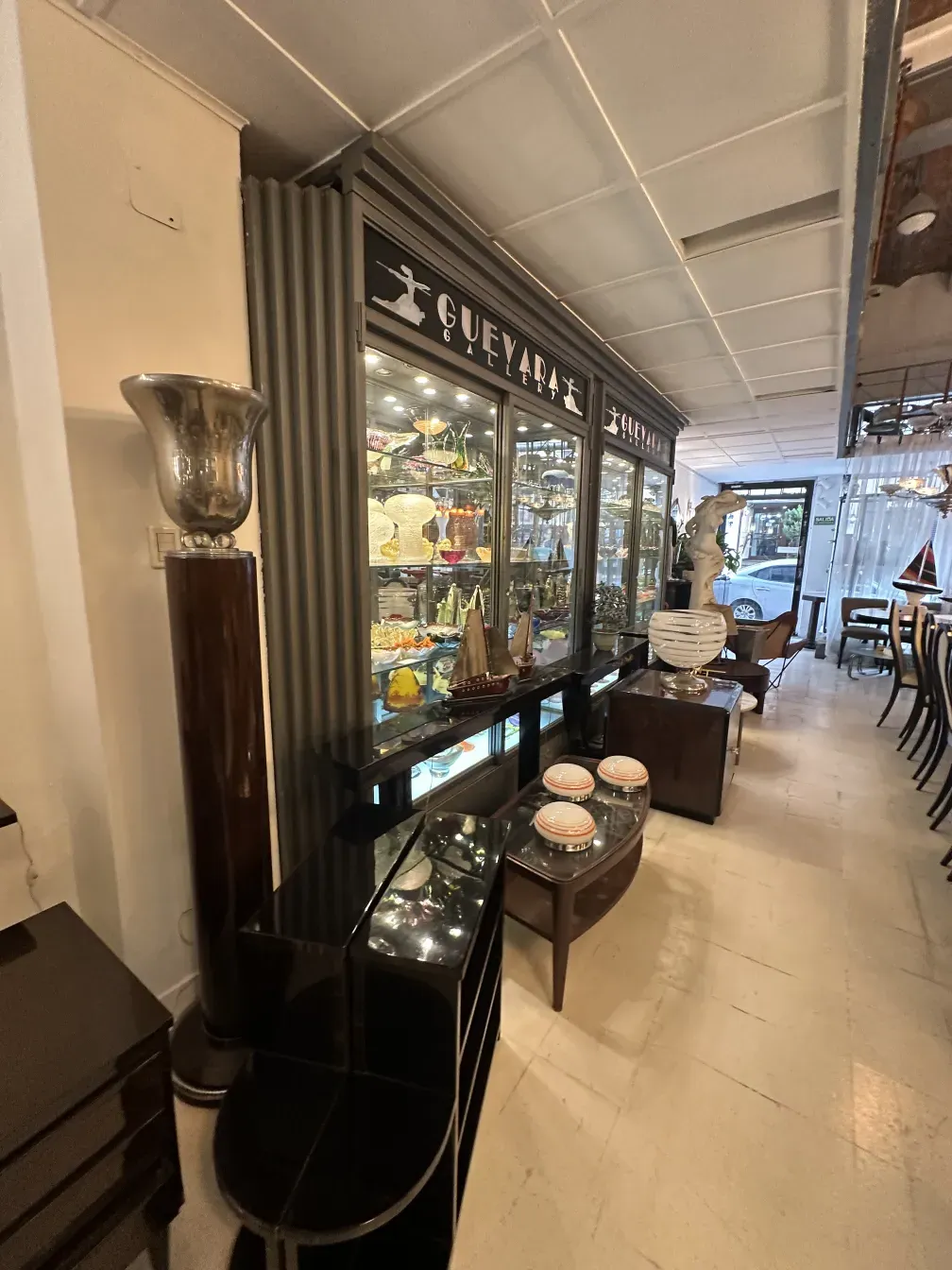 Элегантный старинный торшер в окружении витрин и мебели