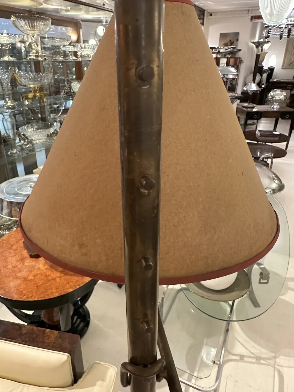 Античный торшер с конусным абажуром и металлической основой в элегантной обстановке.