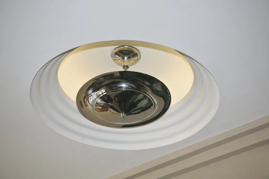 Detailed view of 2 antique hanging lamps in circular shape, set in a modern environment.