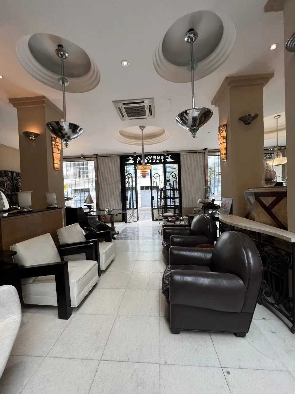View of two vintage hanging lamps in a cozy living room, with comfortable chairs and warm ambiance.