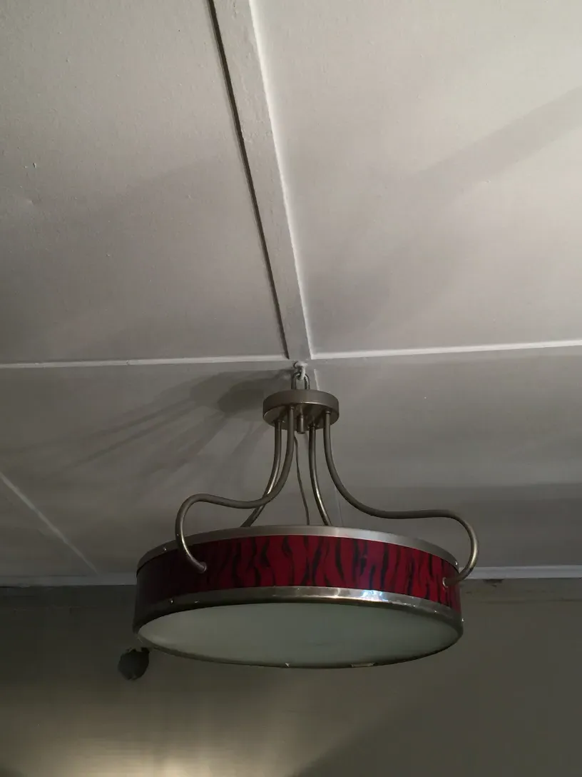 Side view of two antique hanging lamps with a colorful and vibrant design, mounted on the wall.