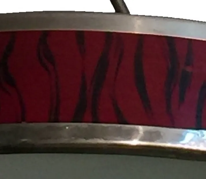 Close-up of 2 antique hanging lamps with decorative red and black design