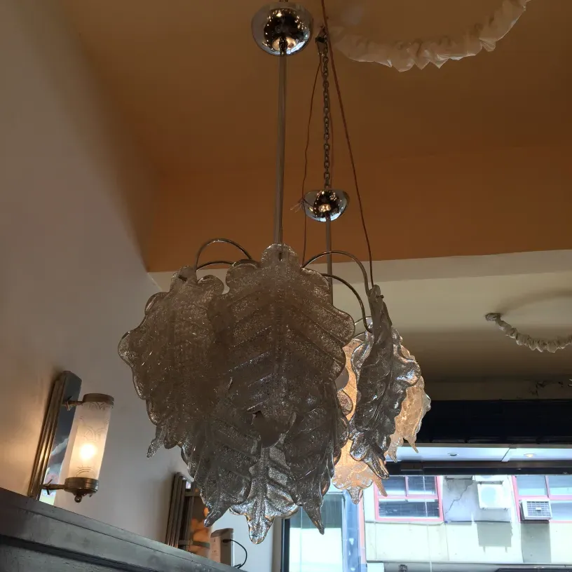two antique hanging lamps shaped like leaves with shiny details, hanging in a lit room