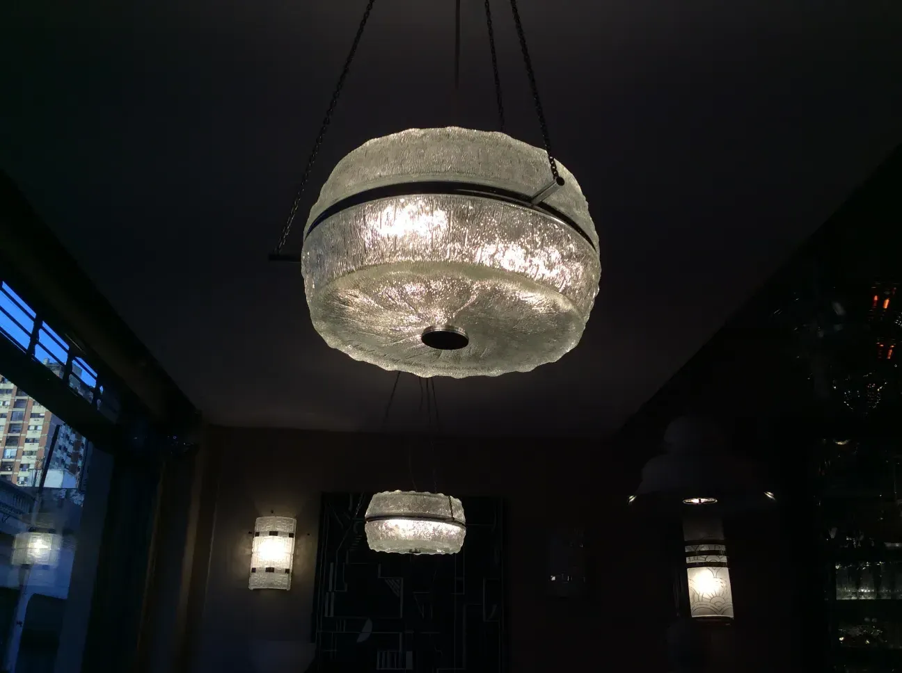 View of 2 antique hanging lamps with soft light, cozy atmosphere.