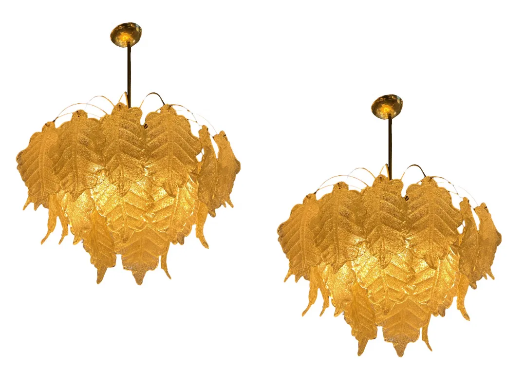 2 antique hanging lamps with golden leaf design in bright setting.