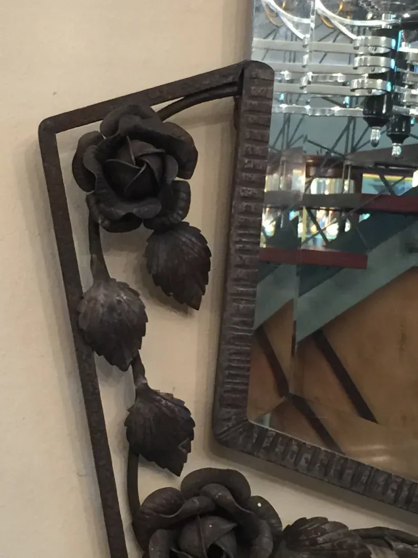 antique mirror with a dark floral decorated frame