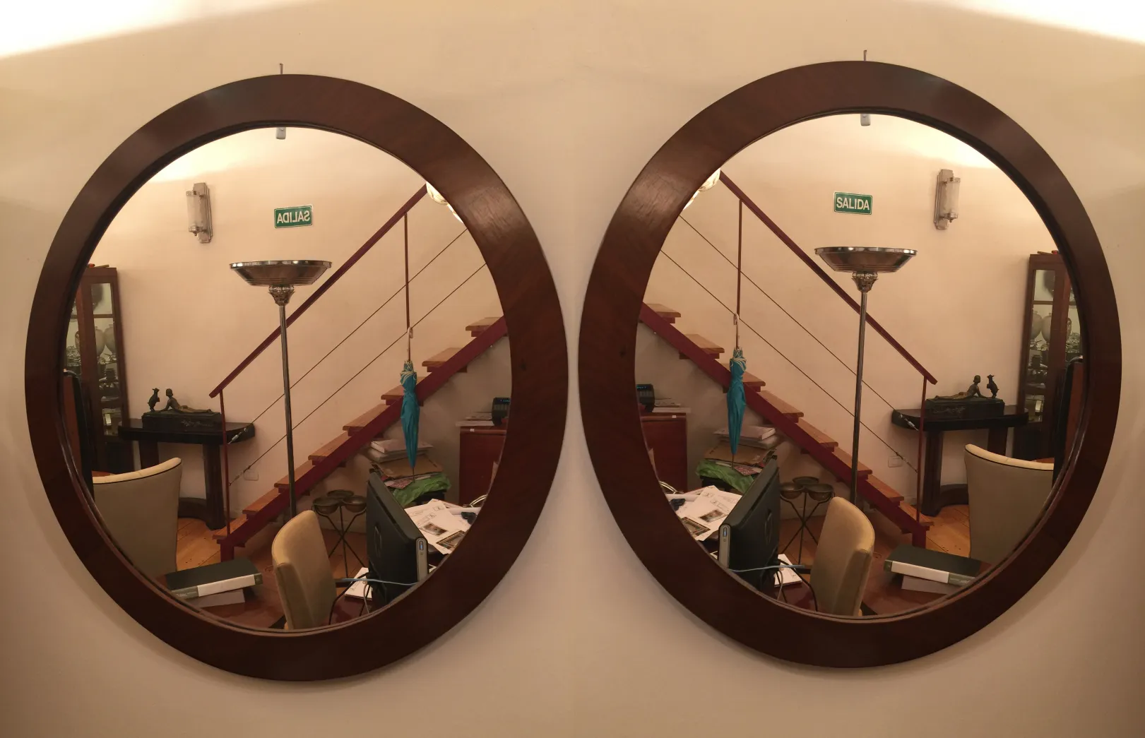 antique round wall mirror with stairs in the background