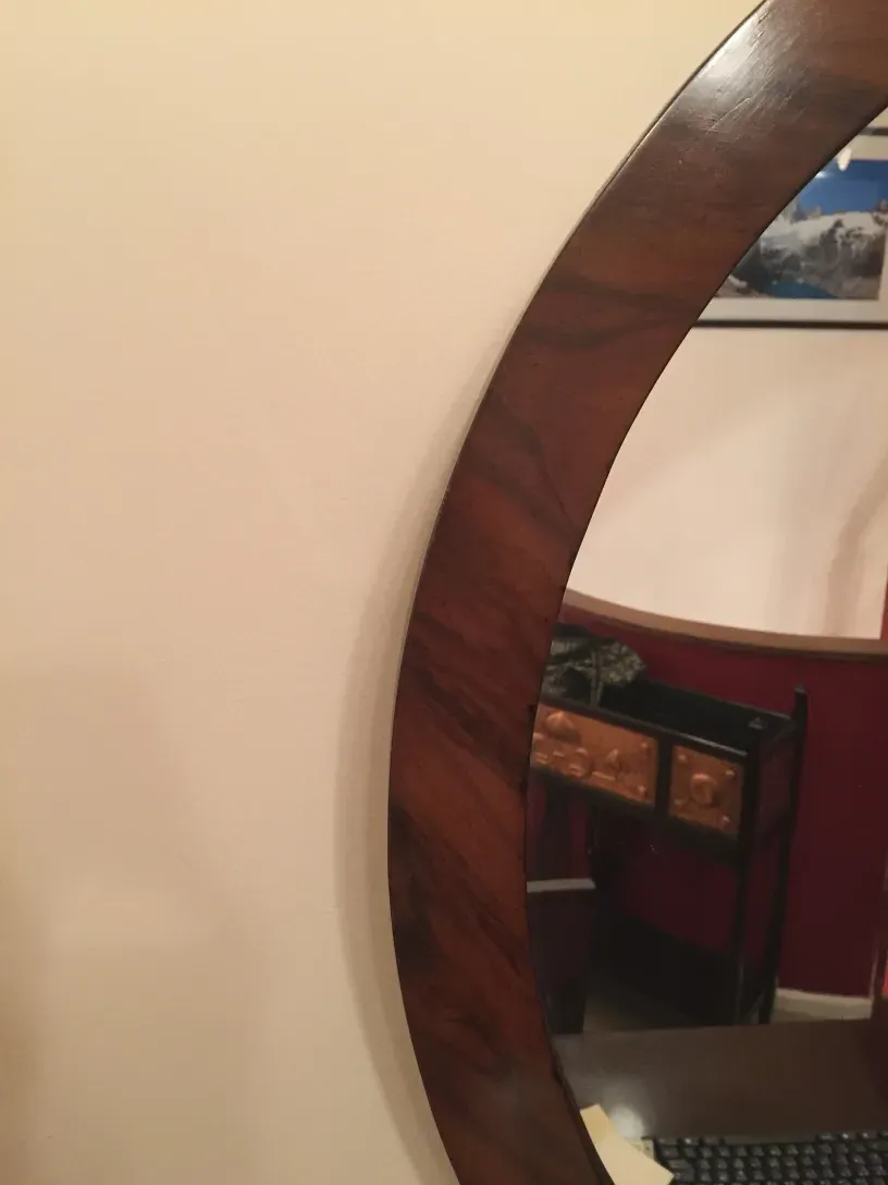 antique round mirror on the wall with decoration