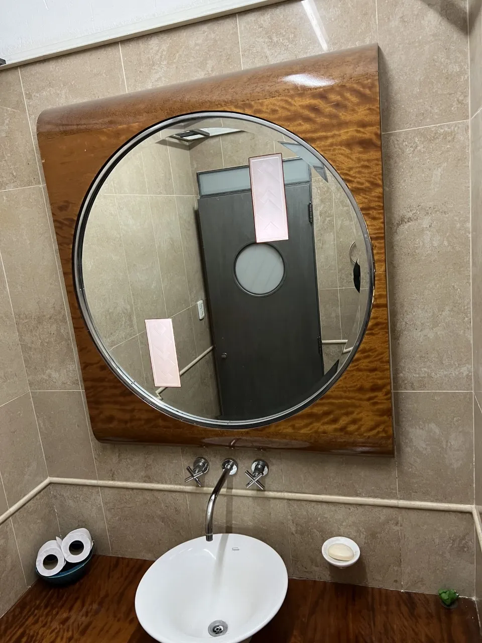 round antique mirror with brown frame in bathroom