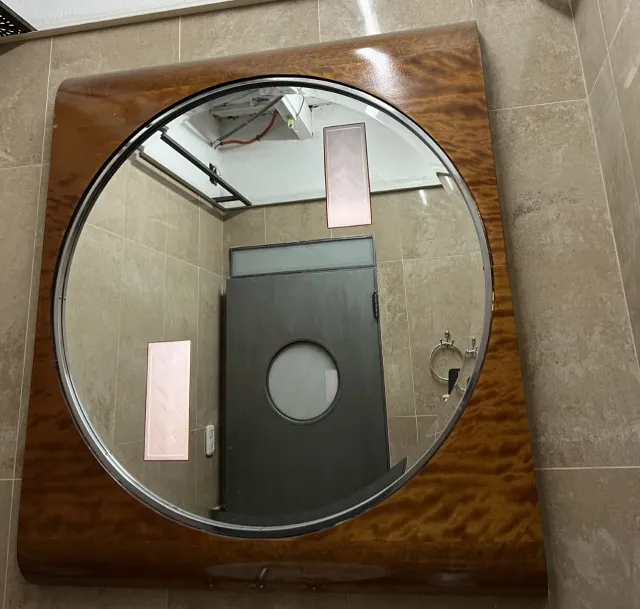 antique oval mirror with decorative frame in a bathroom
