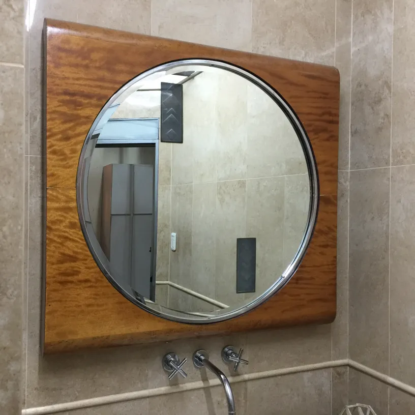 round antique mirror in a bathroom with modern decor