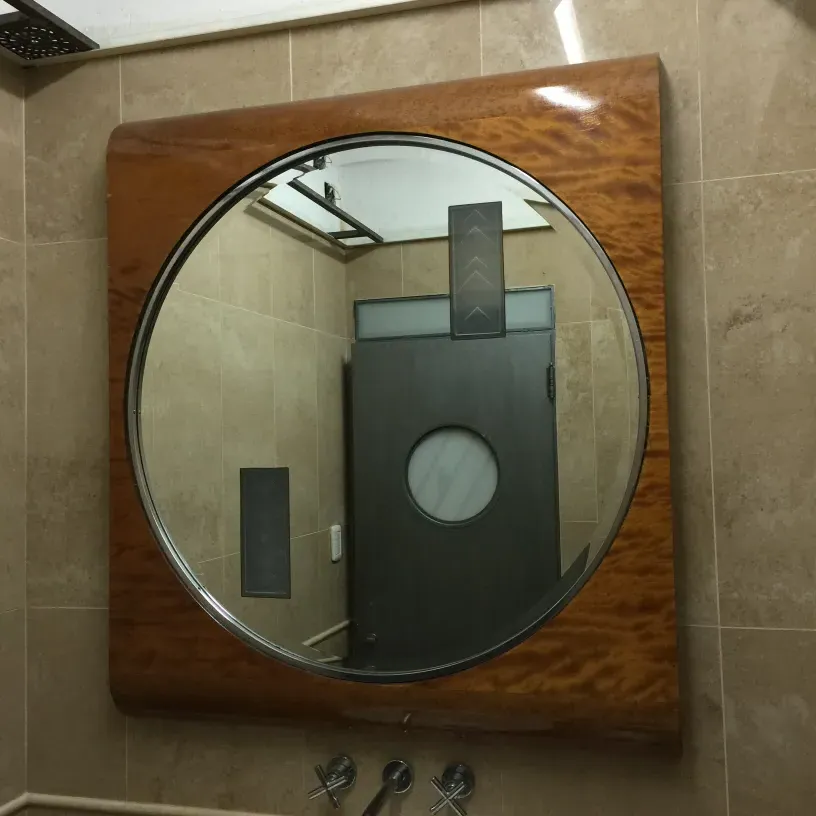 antique mirror with light-colored frame in circular shape