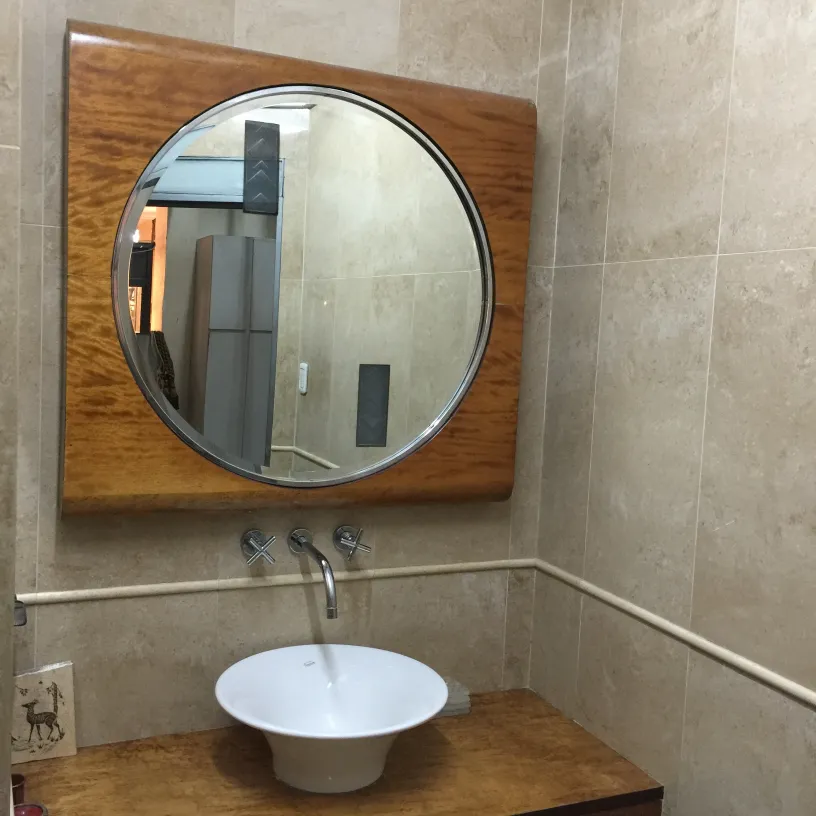 antique round mirror in softly lit bathroom