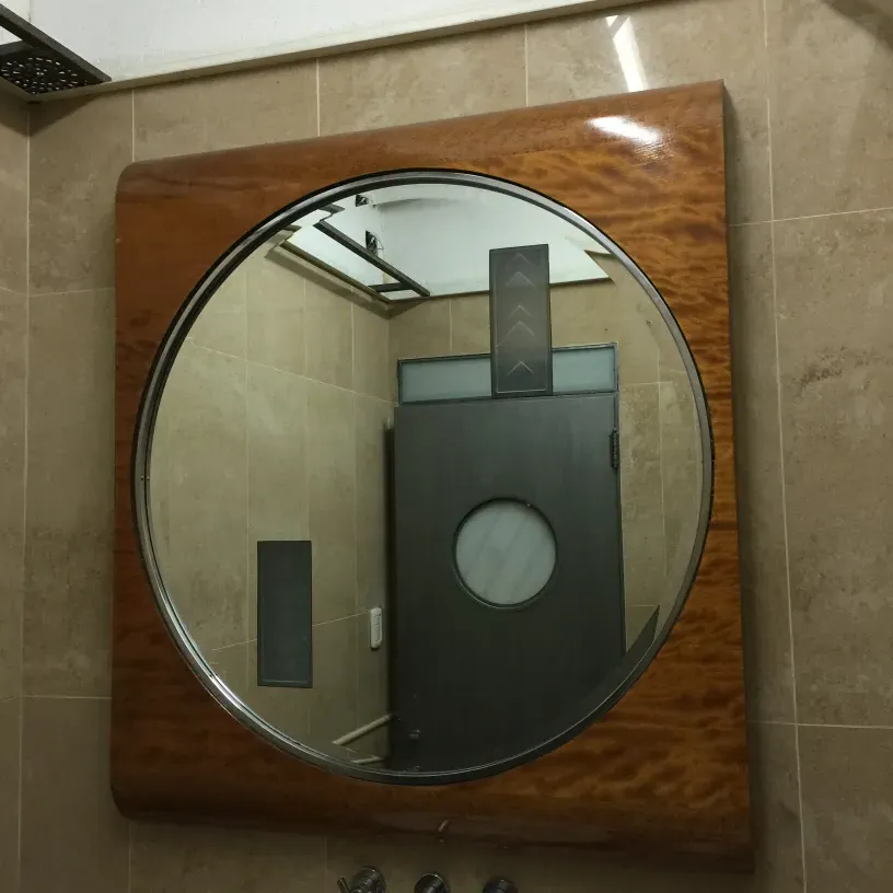 Antique mirror with classic frame and circular surface.