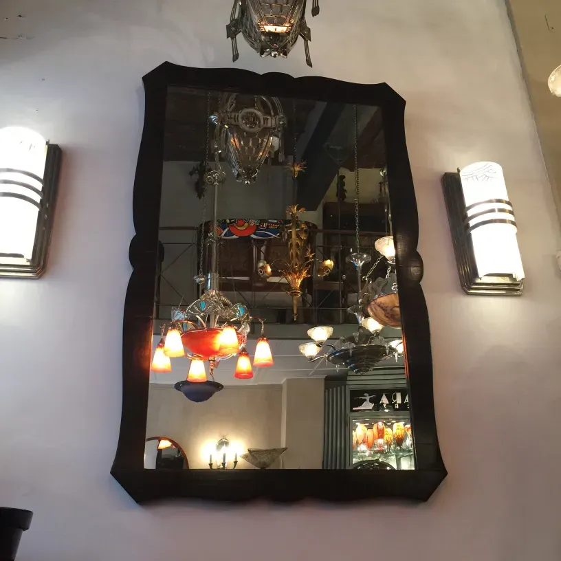 antique mirror with decorative frame and light fixtures around