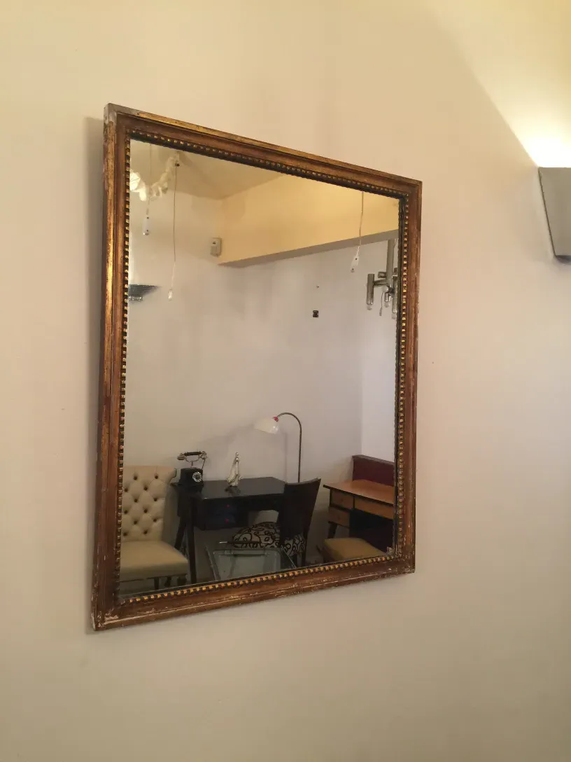 antique mirror in gilded frame hung on the wall