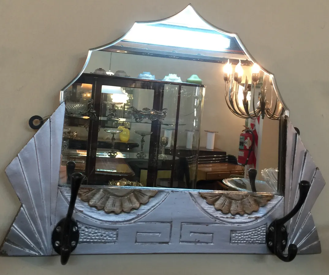 Antique mirror with decorative features and hooks