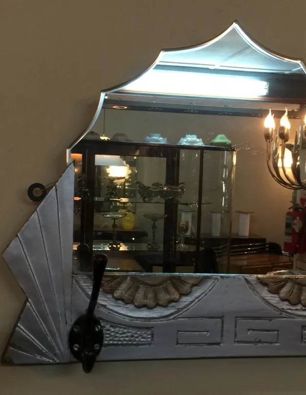 antique mirror with an impressive and elegant decorative frame, surrounded by ornamental objects