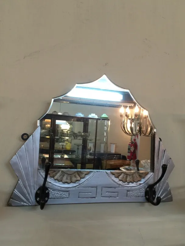 antique mirror with decorative details and hooks