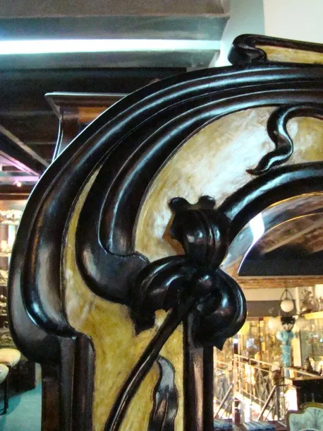 Antique decorative mirror with art nouveau details, dark colors.