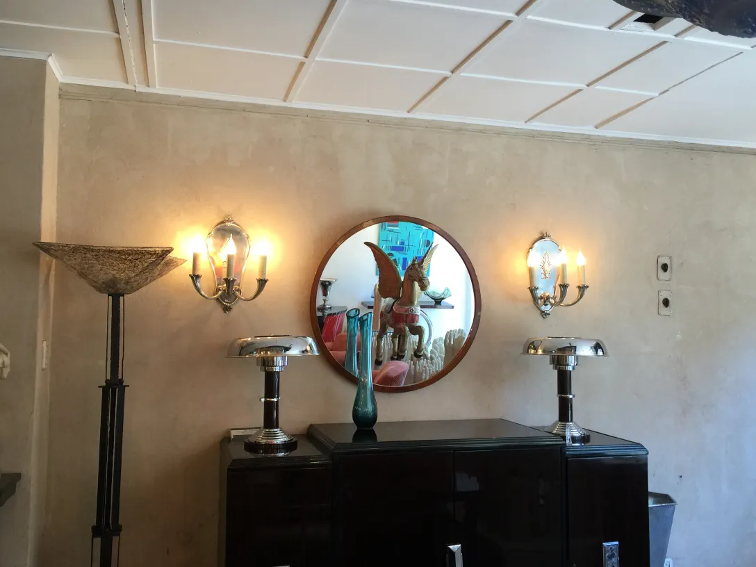Round antique mirror with decorative details reflecting a warm ambiance.