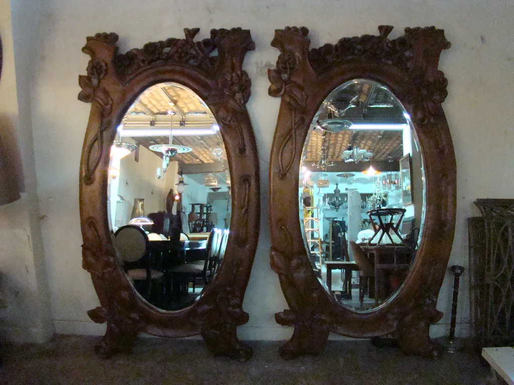 two antique mirrors with decorative frames in a cozy setting