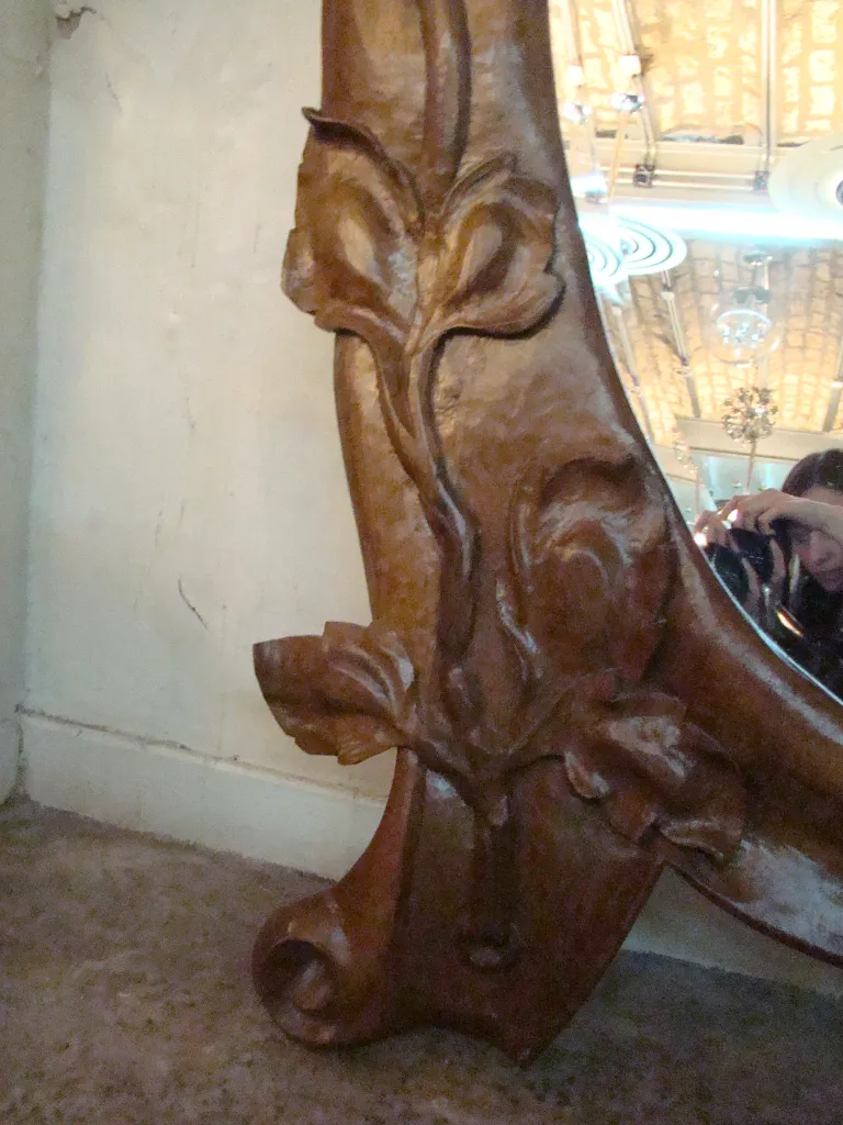 antique mirror with a carved frame featuring floral designs