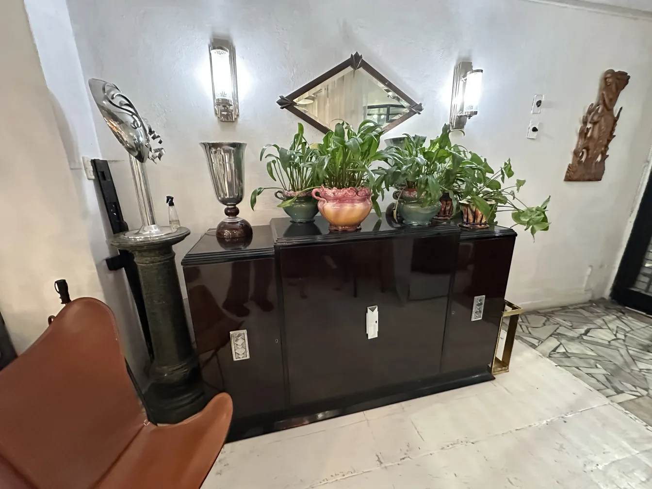 antique mirror on a wall, decorated, plants nearby