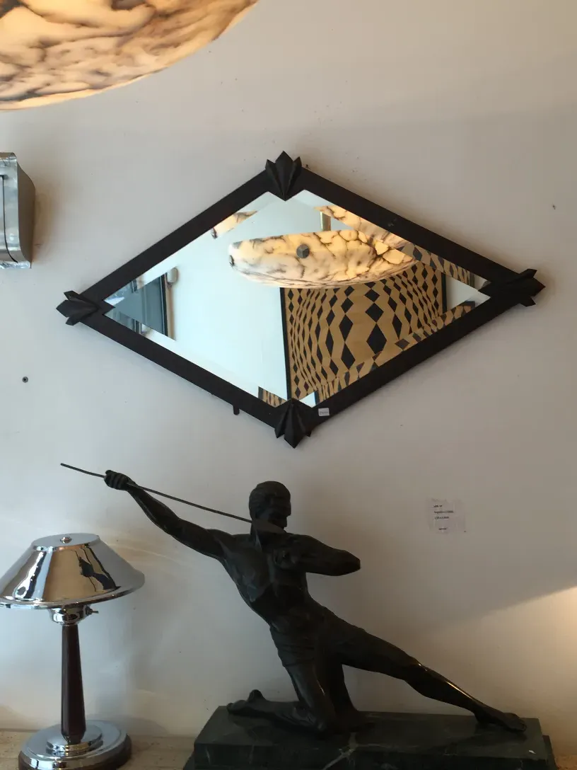 antique diamond-shaped mirror with bright reflections and detailed frame