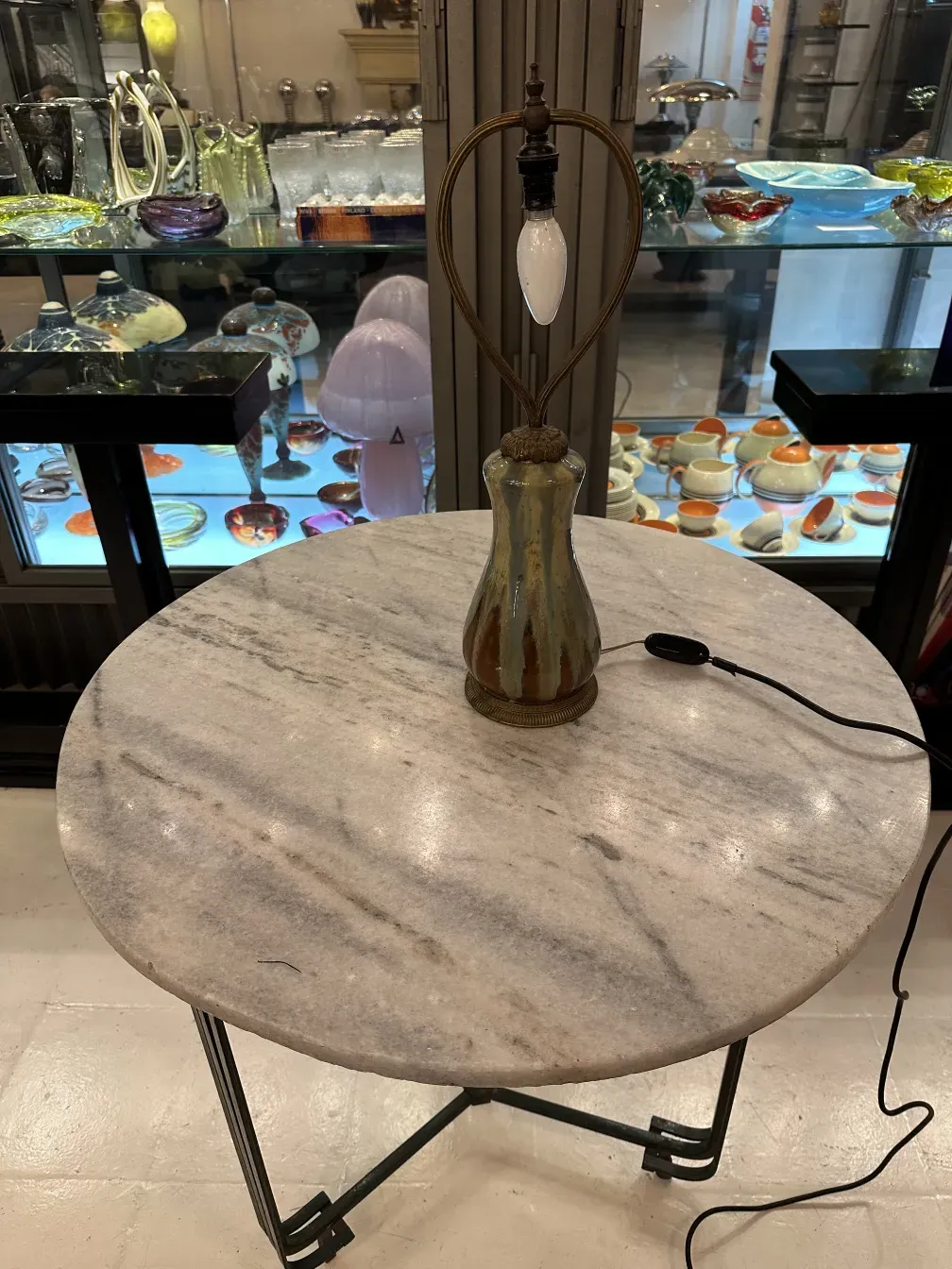 Luminária de mesa antiga com base de vidro, ambiente elegante.